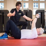 Im Therapiezentrum Kronenhof in Berlingen trainiert Physiotherapeut Manuel Kotzur mit Wolfgang Lichey. Auf dem Bild übt Lichey, wie man nach einem Sturz aus eigener Kraft wieder aufstehen kann. (Bild: Reto Martin)