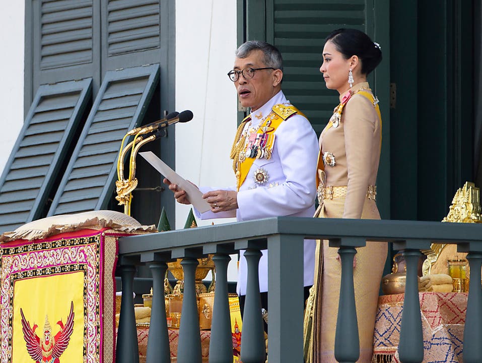 Thailands König Maha Vajiralongkorn bedankte sich am Montag in Bangkok vom Balkon des Grossen Palastes aus beim Volk für die vielen guten Wünsche. Der 66 Jahre alte Monarch und seine neue Frau, Königin Suthida (40), wurden von mehr als 40'000 Menschen bejubelt. (Bild: KEYSTONE/AP/WASON WANICHAKORN)