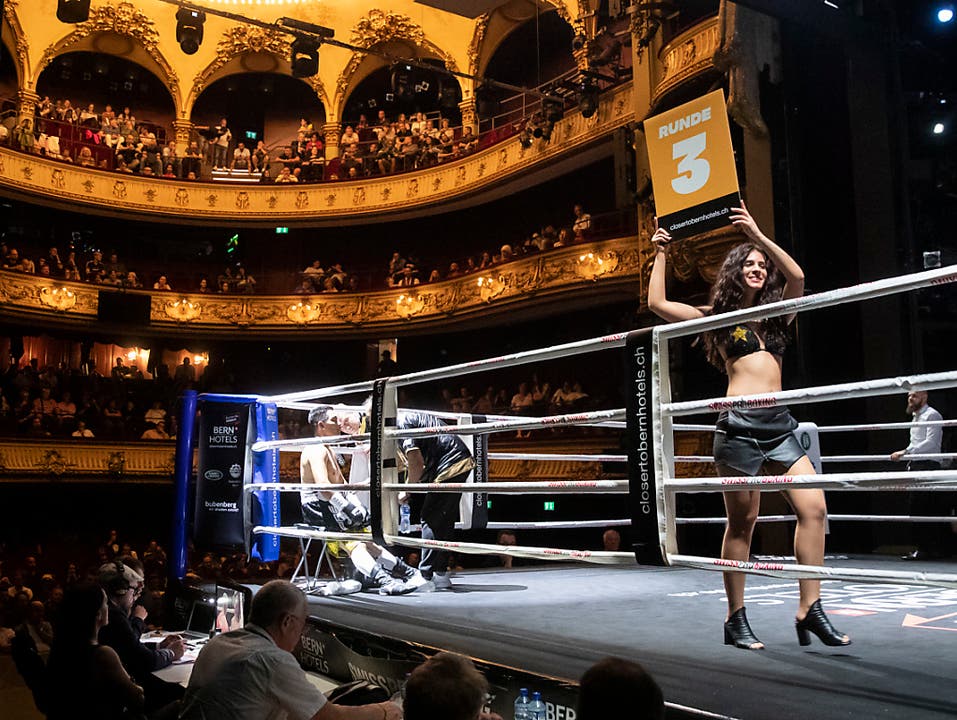 Schauplatz war das Berner Stadttheater. Während sich die Boxer in der Ecke eine Pause gönnen, zeigt ein Ringgirl die nächste Runden an (Bild: KEYSTONE/PETER KLAUNZER)