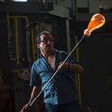 Glasmacher Manuel Cataláo bei der Arbeit an einer Glasflasche, mit der später Köder fürs Fischen gefangen werden. (Bild: Dominik Wunderli, Hergiswil, 11. Juli 2019)