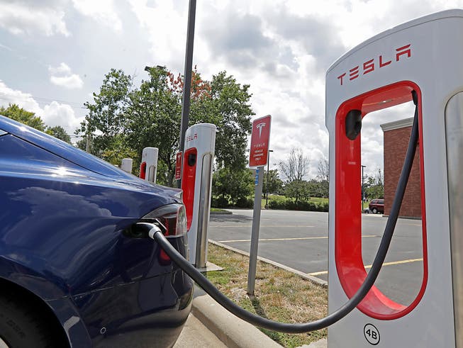 Ein Elektroauto des US-Unternehmens Tesla beim «Tanken» mit Strom. (Bild: KEYSTONE/AP/CHUCK BURTON)