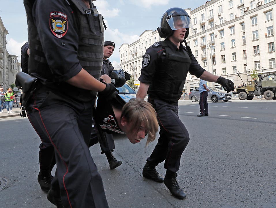 Russische Polizisten führen einen Kundgebungsteilnehmer vor dem Moskauer Rathaus ab. (Bild: KEYSTONE/EPA/YURI KOCHETKOV)