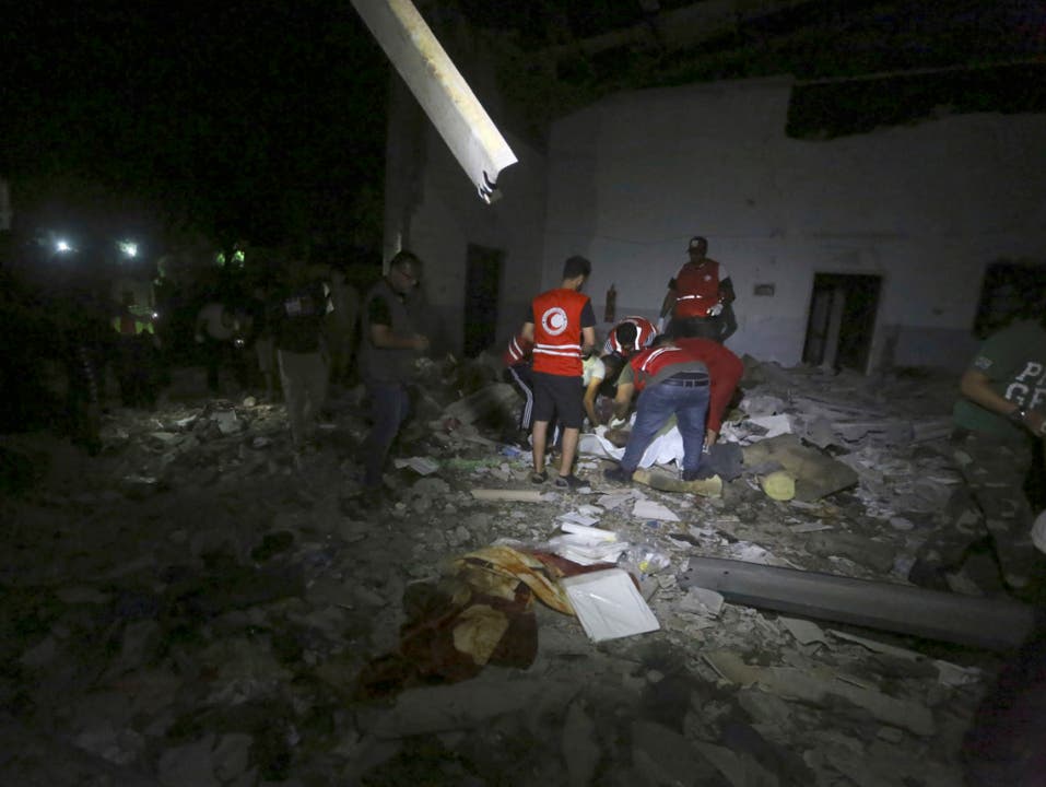Mitarbeiter der Hilfsorganisation Roter Halbmond bergen Opfer nach dem Luftangriff auf ein Flüchtlingslager im Vorort Tajoura nahe der libyschen Hauptstadt Tripolis. (Bild: KEYSTONE/AP/HAZEM AHMED)