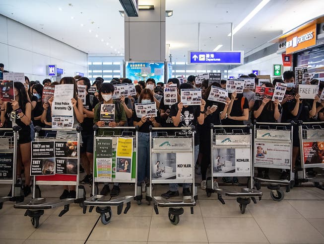 Protestierende blockieren am Dienstag am Hong Kong Chek Lap Kok International Airport den Abflugsektor am Terminal 2. (Bild: KEYSTONE/EPA/LAUREL CHOR)