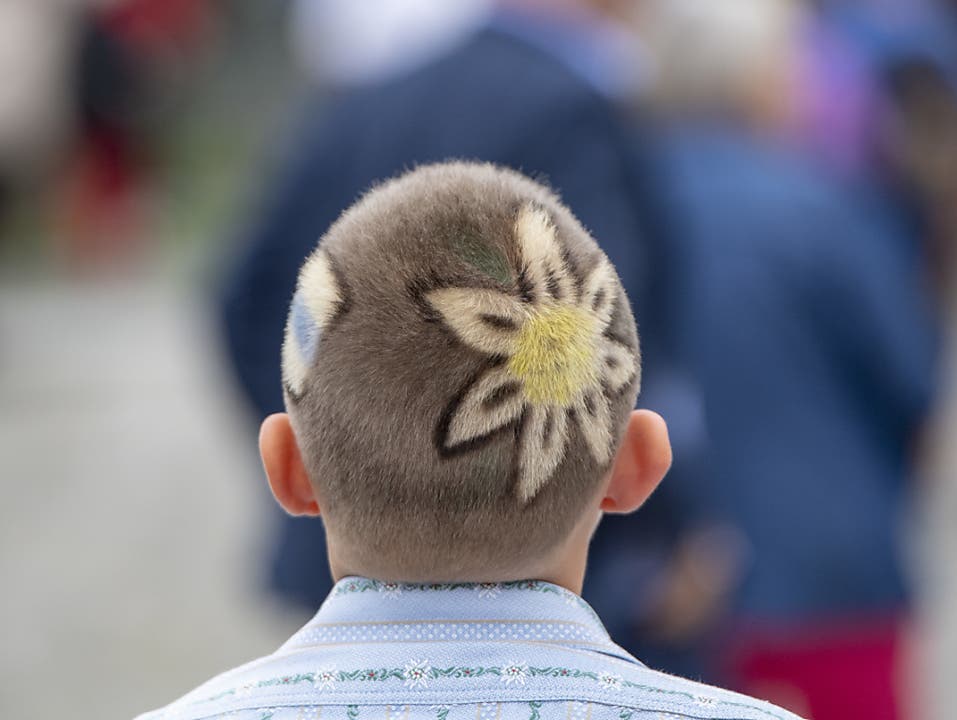 Ein Jungschwinger präsentiert seinen Enzian-Haarschnitt beim Festumzug. (Bild: KEYSTONE/URS FLUEELER)