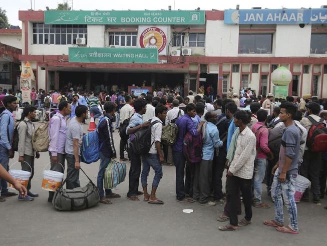 Indische Gastarbeiter in der Region machen sich nach dem umstrittenen Entscheid der indischen Regierung vom Bahnhof in Jammu aus auf den Weg nach Hause. (Bild: Keystone/AP/CHANNI ANAND)