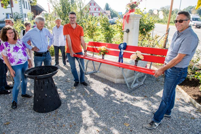 Zur Einweihung des Löffelparks überbringen Stadtpräsident Roger Martin und Stadtrat Christian Zanetti eine rote Sitzbank. (Bild: Reto Martin)