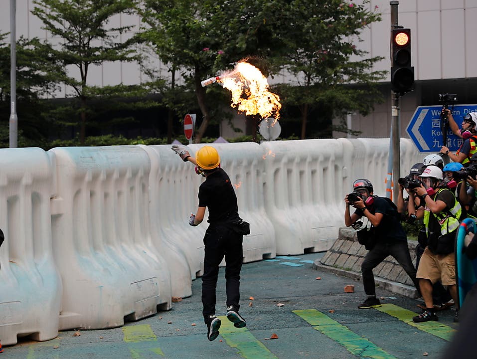 Ein Regierungsgegner wirft bei Protesten in Hongkong einen Molotow-Cocktail. (Bild: KEYSTONE/AP/VINCENT THIAN)