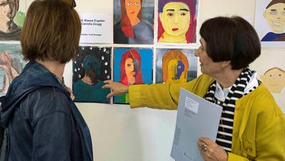 Silvia Peters von der Frauenfelder Bildschule schaut sich mit einer Besucherin die Porträts von Frauenfelder Schülerinnen und Schülern an. (Bild: Andreas Taverner)