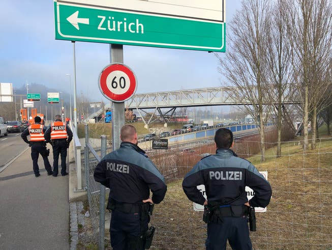 Polizisten sichern eine Autobahnüberführung in St.Gallen für die Durchfahrt des Konvois.