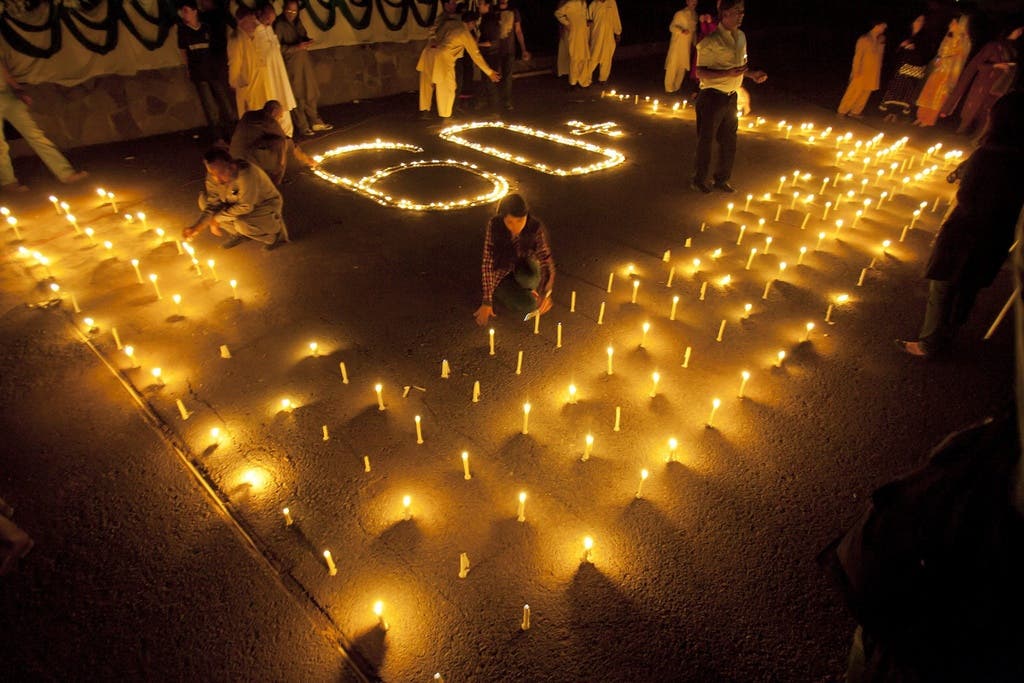 In Islamabad (Pakistan) kreeiren Menschen mit Kerzen die Zahl 60, die für die Stunde Lichterlöschen während der Earth Hour 2012 steht.