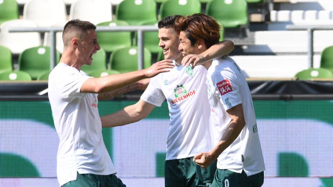 Werders Yuya Osako (r) jubelt mit Milot Rashica und Marco Friedl (l) über sein Tor zum 5:0.