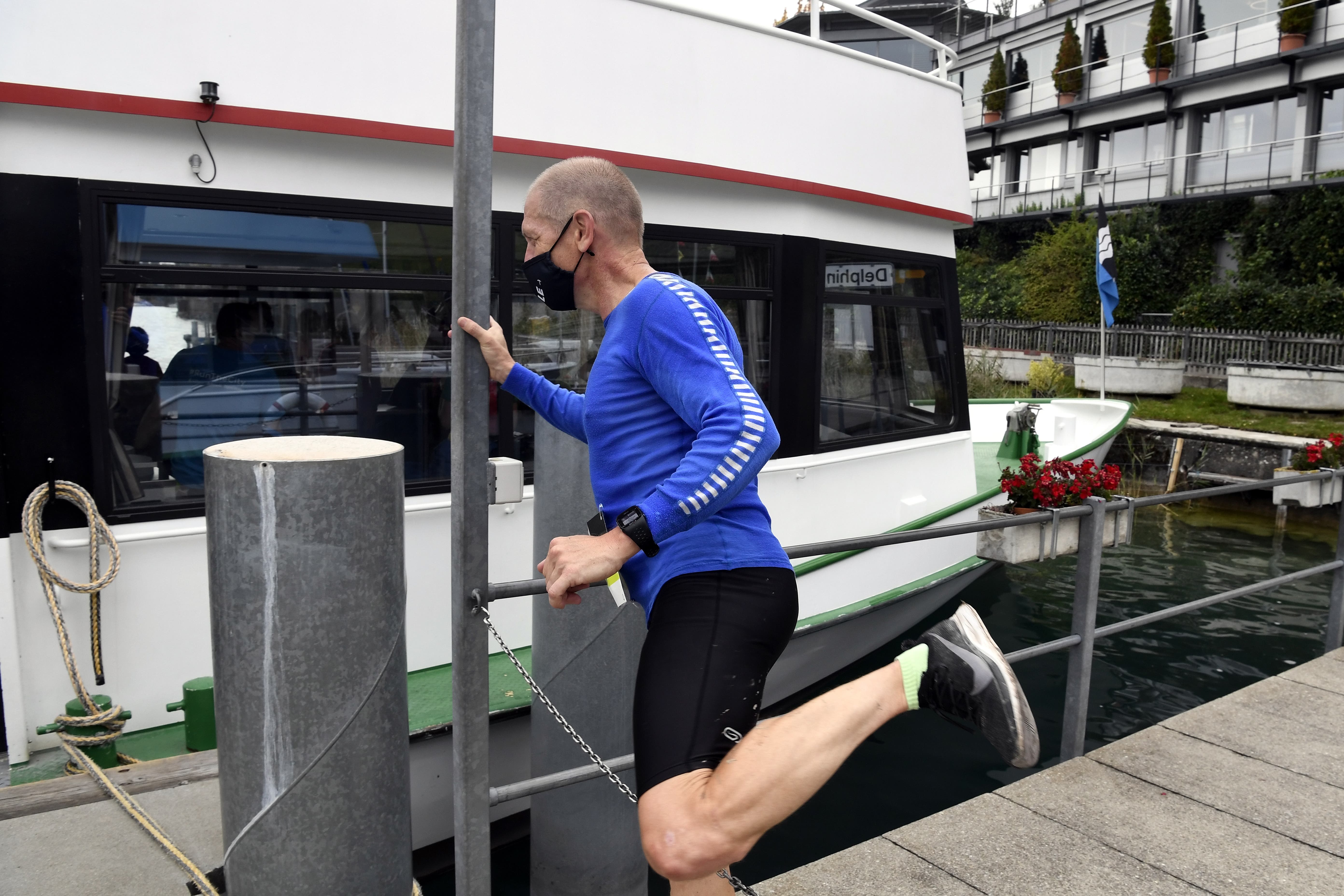 Läufer gehen mit Masken auf das Schiff ueber den Hallwilersee. 