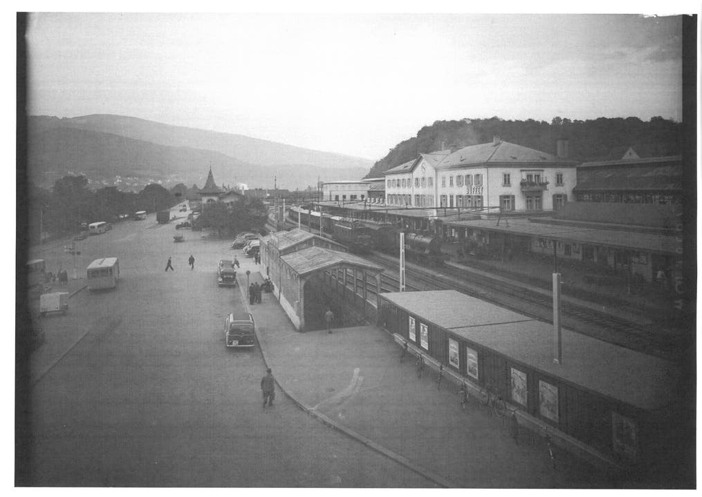 1948: Bahnhofplatz Olten mit Bahnhofgebäude und Güterschuppen vom Dach des Postgebäudes aus gesehen.