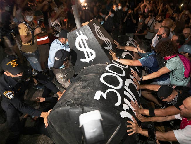 Demonstranten stossen während eines Protests gegen den israelischen Ministerpräsidenten Netanjahu mit der Polizei zusammen. In der Küstenmetropole Tel Aviv trafen sich am Samstagabend Demonstranten unter anderem am zentralen Habima-Platz. Foto: Sebastian Scheiner/AP/dpa