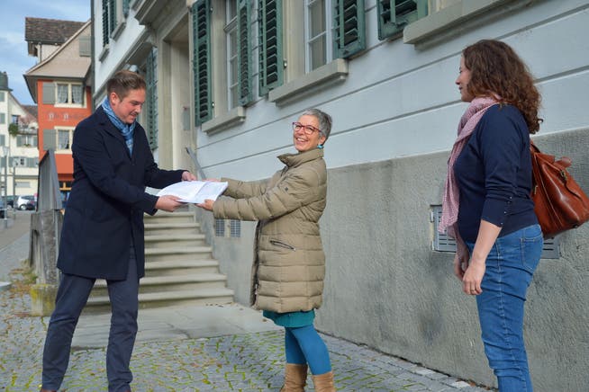 Die SP-Vorstandsfrauen Dana Wassmann und Xenja Magri überreichen die Unterschriften an Stadtschreiber Reto Marty.