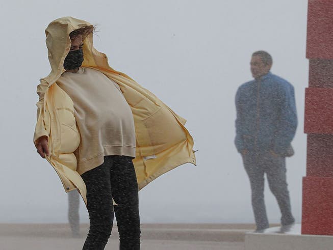 dpatopbilder - Eine Frau kämpft bei Regen gegen den starken Wind in Nizza an. Nach Unwettern und Überschwemmungen in der Region der südfranzösischen Metropole werden nach Medienberichten mindestens neun Menschen vermisst. Foto: Valery Hache/AFP/dpa