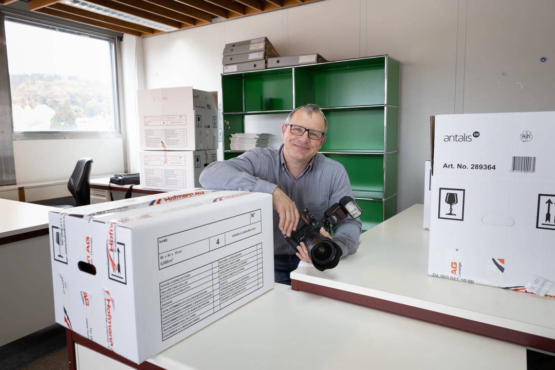 Fotograf Bruno Kissling zwischen vollen Umzugsboxen im alten Büro.