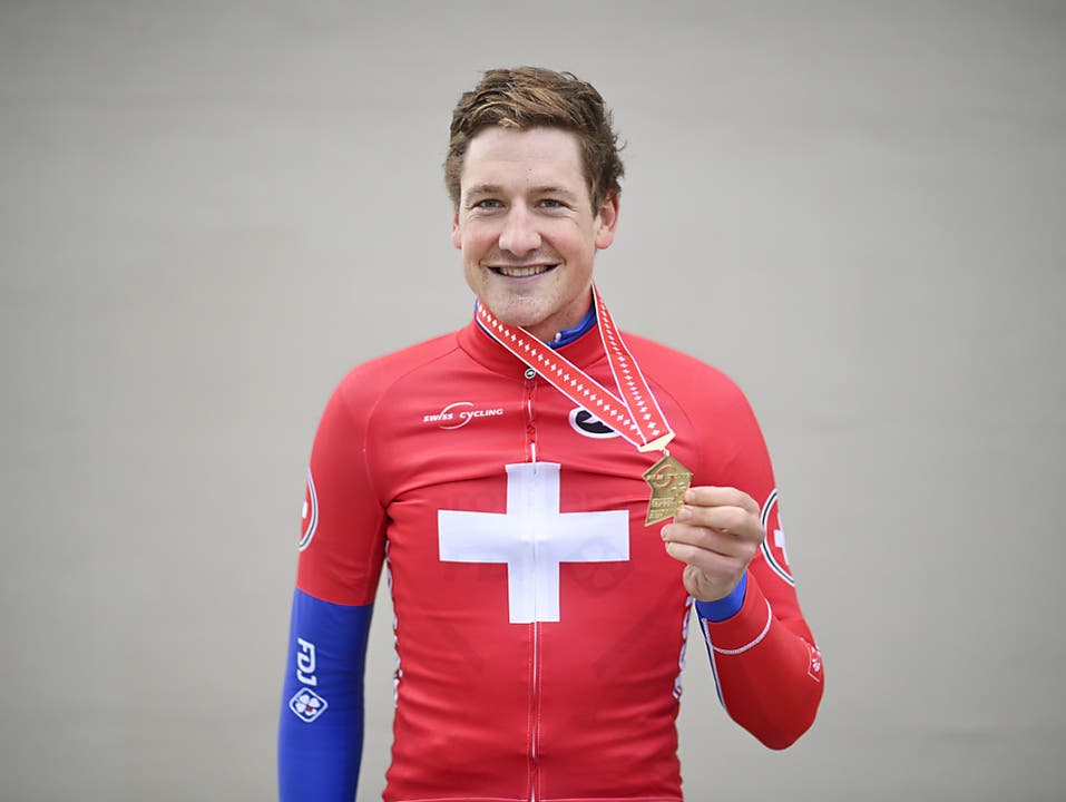 Stefan Küng posiert mit der Goldmedaille und dem Meistertrikot. Der Thurgauer ist der erste Fahrer in der Geschichte, welcher auf nationaler Ebene im gleichen Jahr sowohl im Zeitfahren als auch im Strassenrennen triumphierte