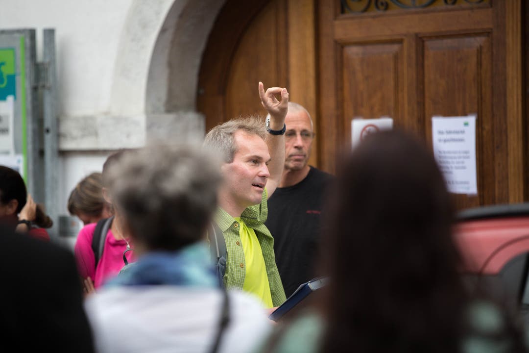 Der Organisator des interreligiösen Spaziergangs, Roland Lehmann, teilt die grosse Teilnehmergruppe vor dem Alten Spital auf