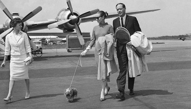 Schauspielerin Audrey Hepburn und Ehemann Mel Ferrer laufen am 30. April 1959 nach einem Flug mit einer Propellermaschine der Swissair übers Rollfeld.