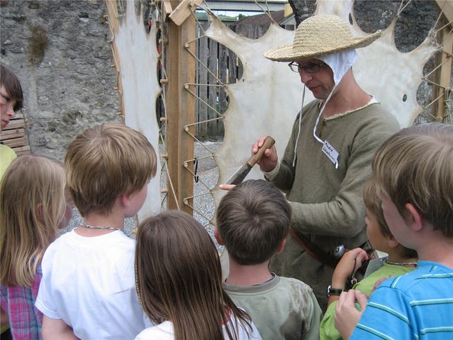 André Schnellmann zeigt Kindern, wie man Pergament herstellt.bär