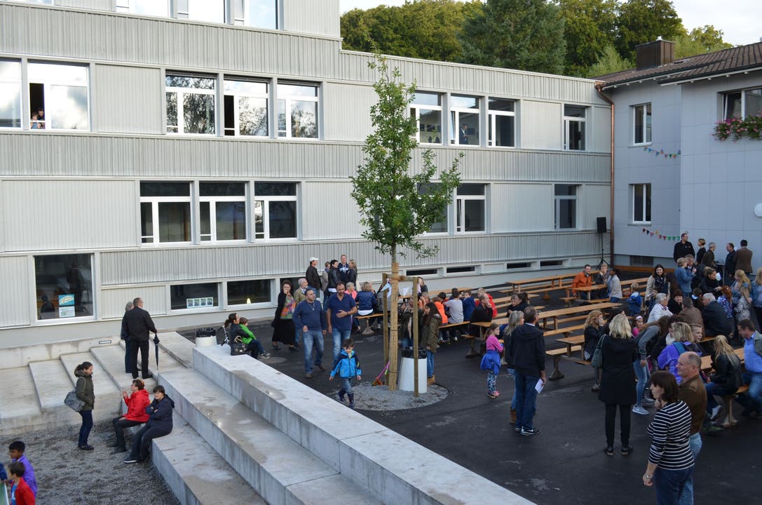 Die Dorfbevölkerung feiert Der neue Holzbau ist mit dem ursprünglichen alten Lindhofschulhaus (re ) verbunden