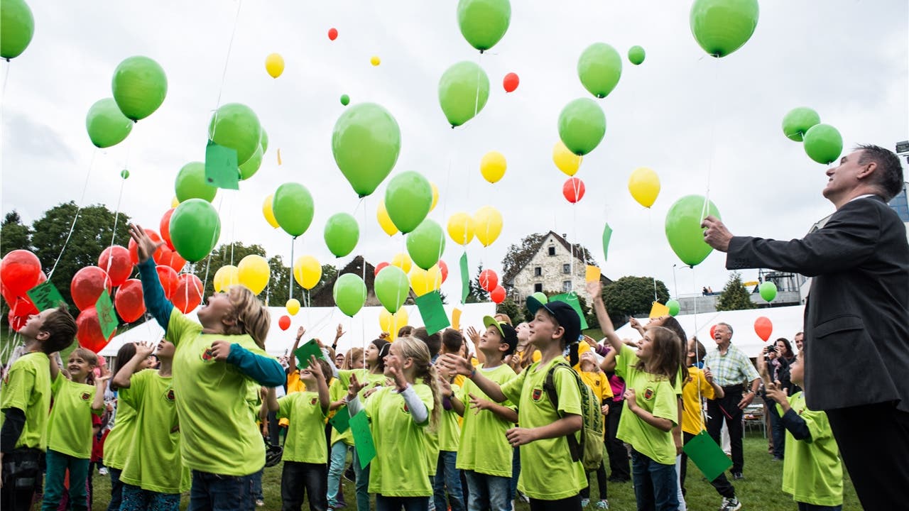 Beobachtet von Regierungsrat Alex Hürzeler lassen die Hallwiler Schüler die Ballone mit ihren Wünschen fliegen.