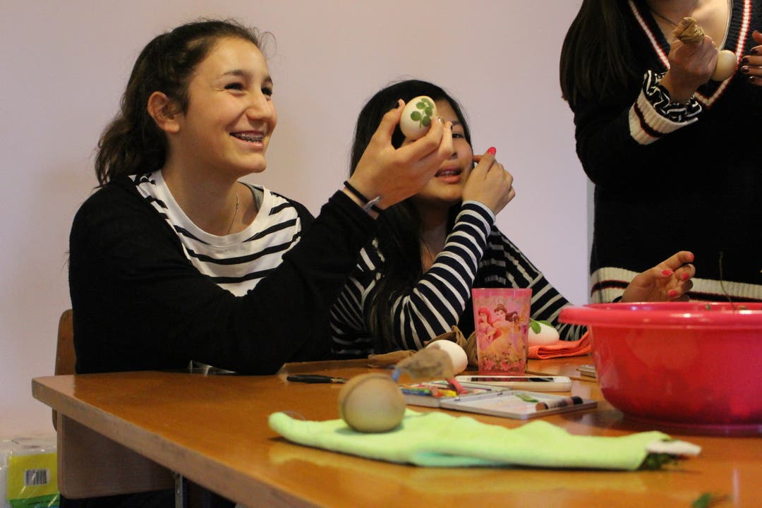 Olivia (links) und Nyma, beide 13, haben grossen Spass am Eierfärben. Für beide ist es das erste Mal.