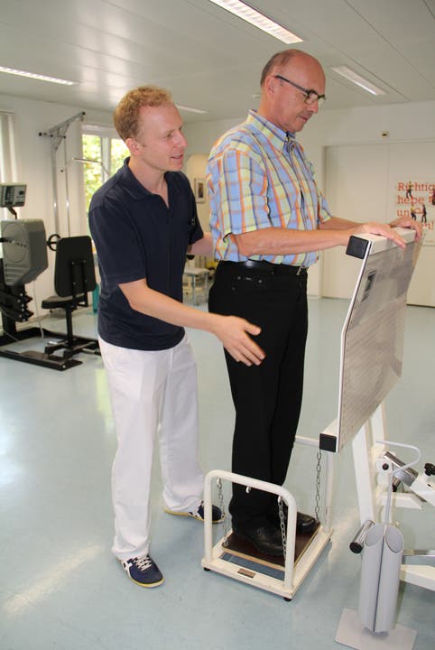 Mathias Lehner, Leiter Therapien, erklärt einem Besucher die Geräte in seinem Therapieraum