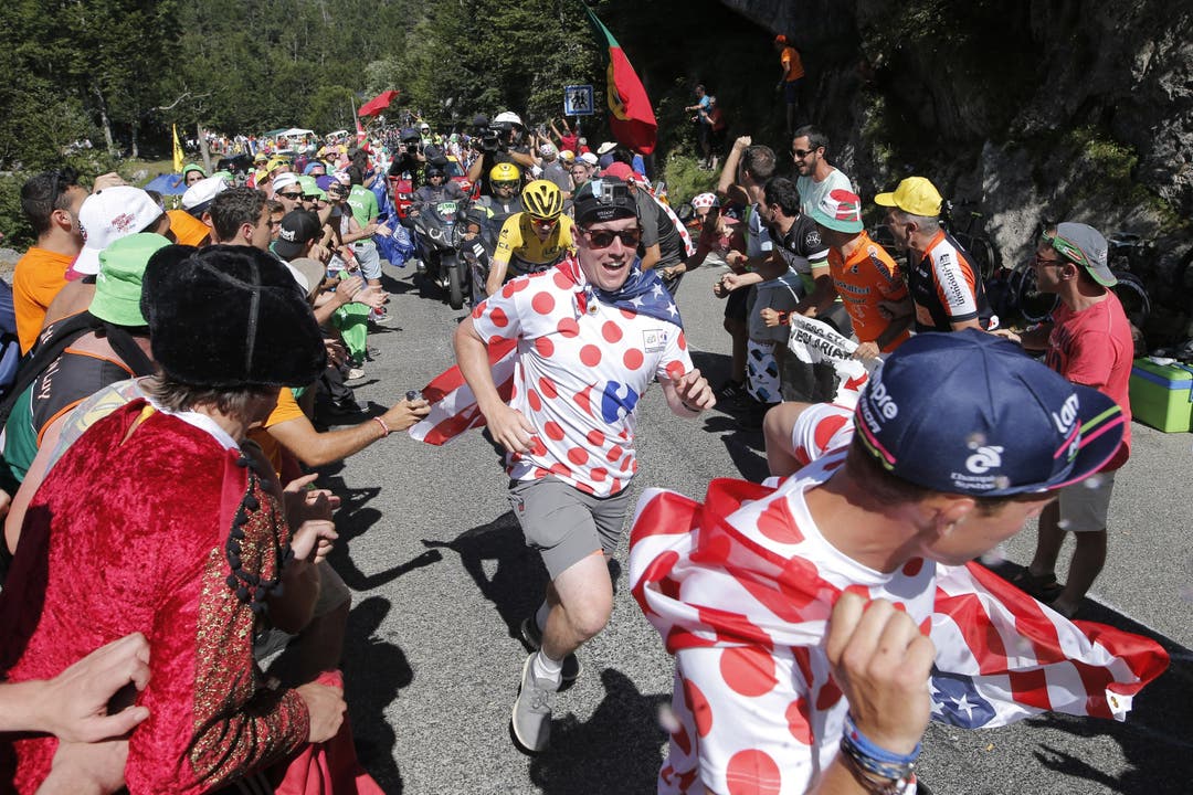 Tour-Leader Chris Froome (mit gelbem Helm) hat es nicht einfach: Immer wieder wird er von mitrennenden Fans gestört