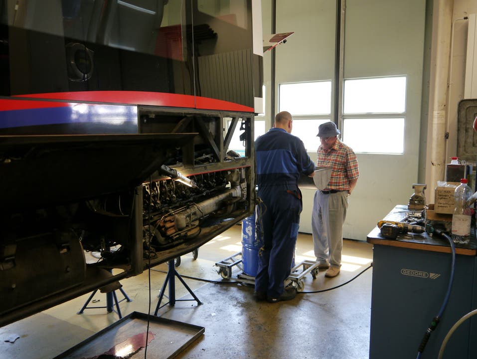 Ein Mechaniker erklärt dem Besucher seine Tätigkeit