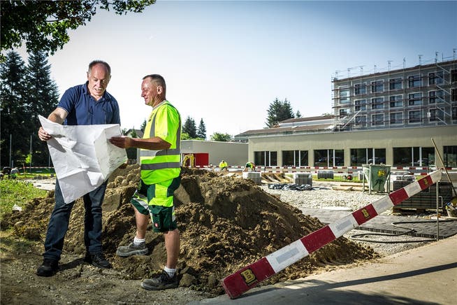 Unter Zeitdruck wird bei der Primarschule Rüsler ein Pavillon gebaut. Bauverwalter Sandro Fischer (l.) und Polier Frank Brogle besprechen die nächsten Schritte. Cris Iseli