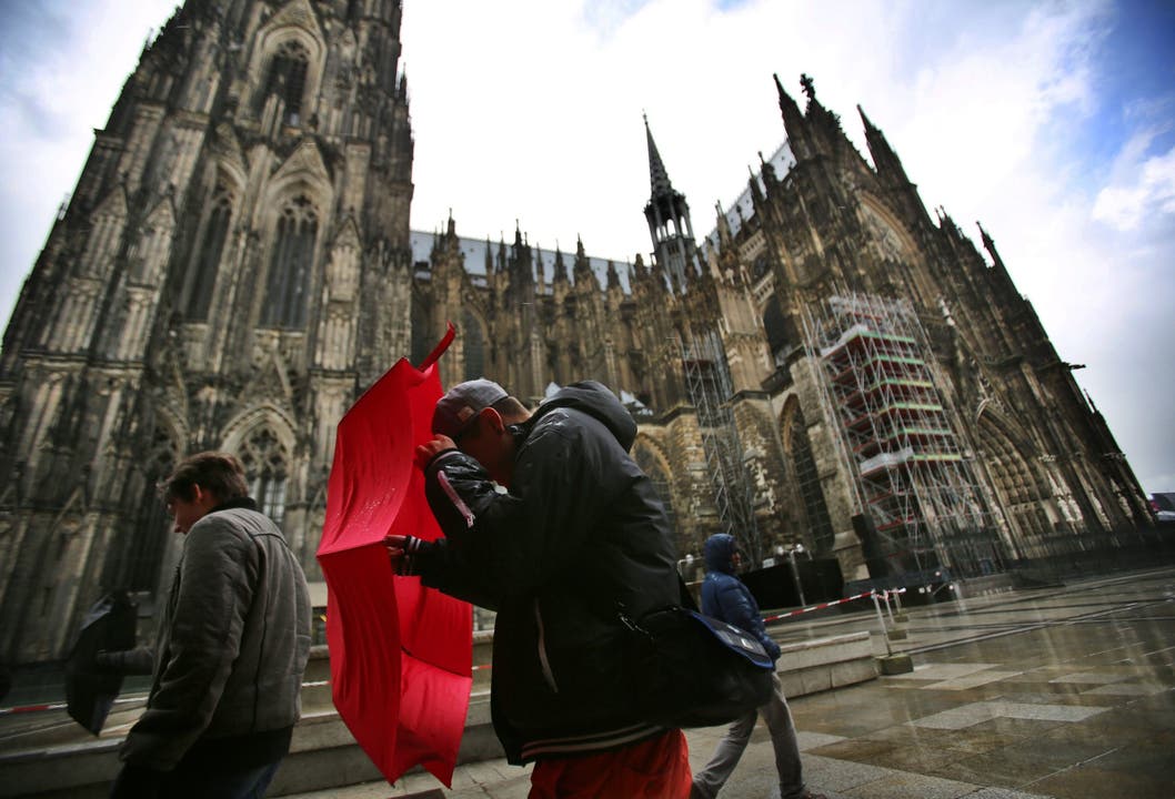 Touristen kämpfen gegen den Sturm in Köln.