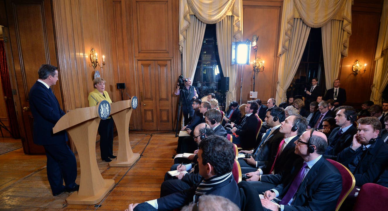 Die deutsche Bundeskanzlerin Angela Merkel drückt bei einer Medienkonferenz mit dem britischen Premierminister David Cameron ihr Beileid aus.