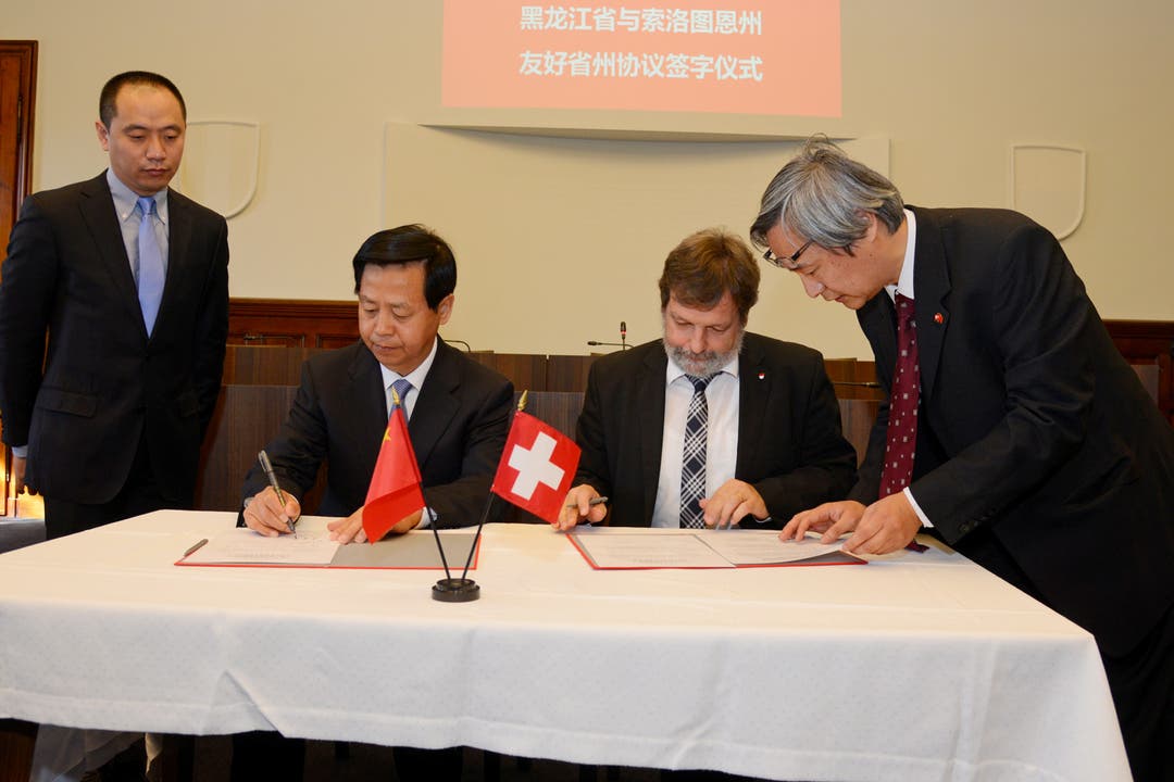 Parteisekretär Wang Xiankui und Landammann Roland Heim unterschreiben die Vereinbarung