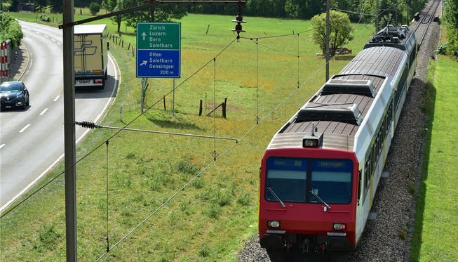 Ein Triebwagen der OeBB, unterwegs auf dem sanierungsbedürftigen Streckenabschnitt vor der Oensinger Dünnernbrücke (hinten rechts).