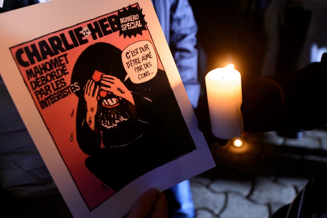 Ein Cover des «Charlie Hebdo» wird in Lausanne getragen