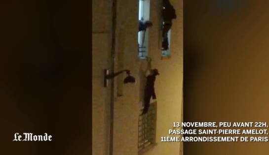 Eine Frau hält sich verzweifelt an einer Fenstervorrichtung fest auf der Flucht vor den Attentätern im Bataclan.