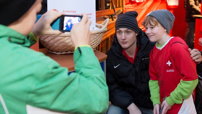 Dean Kukan posiert anlässlich eines Charity-Auftritts des Nationalteams in Chur mit einem jungen Fan für ein Foto.