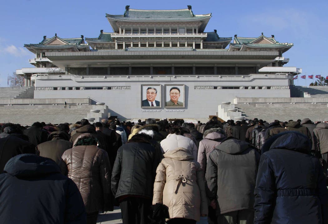 Nordkoreaner versammeln sich am Kim Il Sung Square und verbeugen sich vor den Porträts ihrer früheren Führer. Das sind Kim Jong Il sowie sein Grossvaters und «ewiger Präsident» Kim Il Sung.