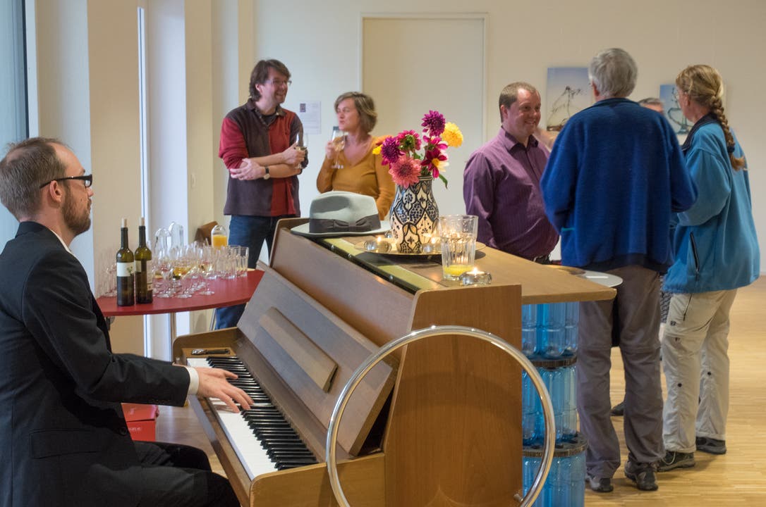 Pianist Felix Stocker und Vernissage Besucher.