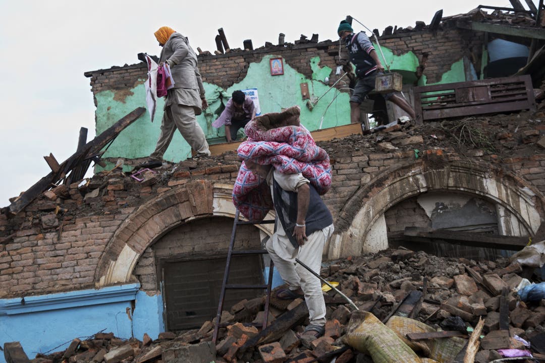Überlebende suchen in ihren eingestürzten Häusern nach ihren Habseligkeiten.