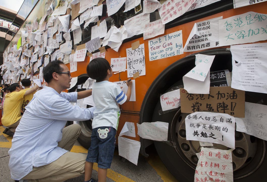 Vater und Sohn hinterlassen eine Nachricht am Demokratie-Bus