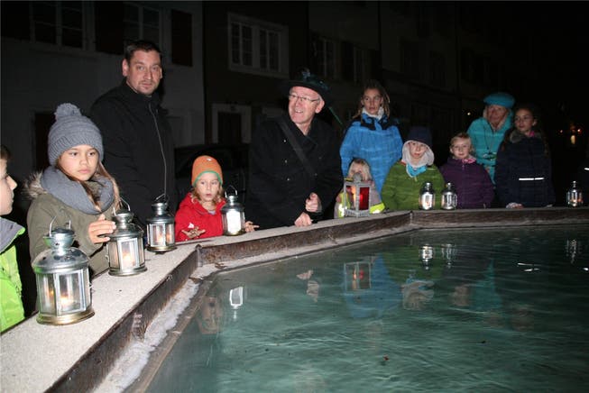 Nachtführer Adelbert Ruoss (Mitte) weihte die Kinder am Rösslibrunnen und im Schein der Laternen in die Geheimnisse der Laufenburger Altstadt ein. Peter Schütz