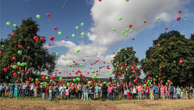 Zum Zeichen des Neubeginns liessen die Dottiker und Hägglinger Primarschüler und Lehrer los, indem sie gemeinsam rote und grüne Luftballons steigen liessen.