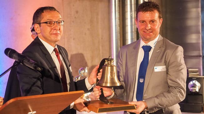 Landstatthalter Urs Hofmann übergibt Gemeindepräsident Ueli Haller die obligate Glocke für das neue Gemeindehaus.