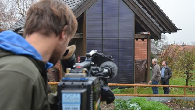Kameramann Iwan Aeschbacher filmt Gemeindeammann Daniel Appert und Fernsehjournalist Reto Holzgang bei Besichtigungen im Dorf.