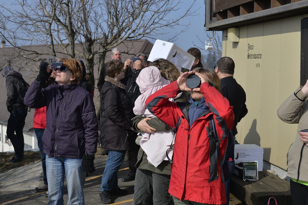 Rund 50 Personen verfolgen bei der Sternwarte auf dem Grenchenberg die Sonnenfinsternis mit Spezialbrillen und Filter