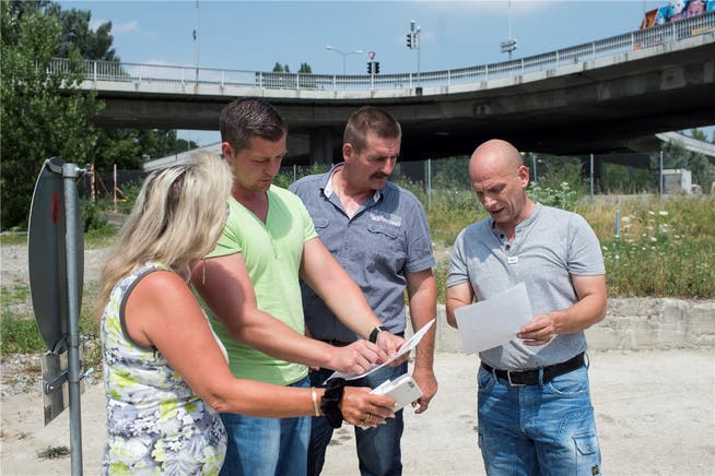 Vertreter der Fahrenden – Iris Graf, Mike Gerzner, David Hauser und Daniel Huber (rechts) – begutachten den künftigen Durchgangsplatz in Altstetten.Keystone